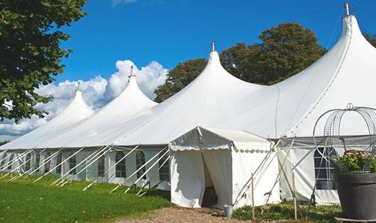 a line of portable restrooms in a shaded area, offering a comfortable experience for users in Raymond